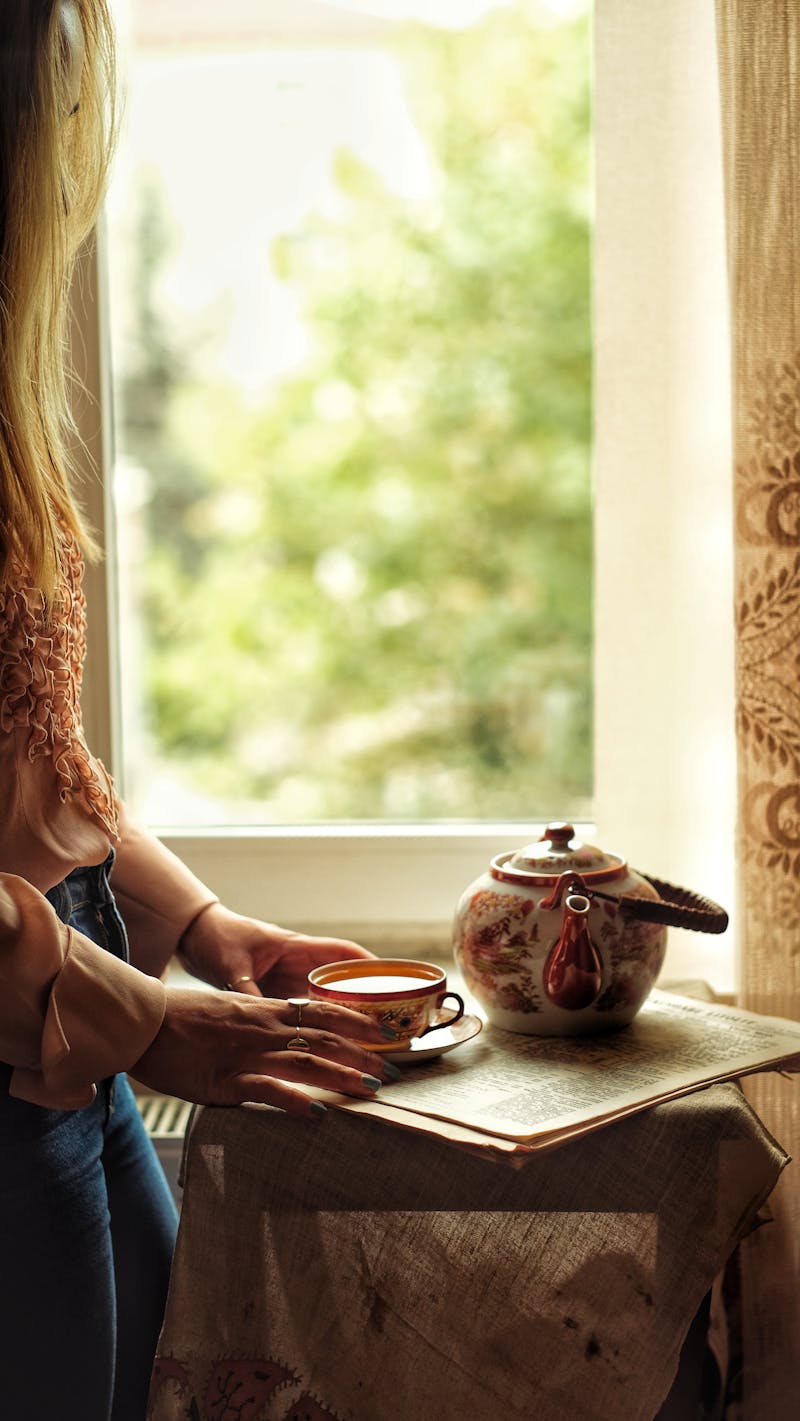 A folded sweater, a ceramic mug, and a wooden bowl on linen — items in everyday rotation, soft natural light.
